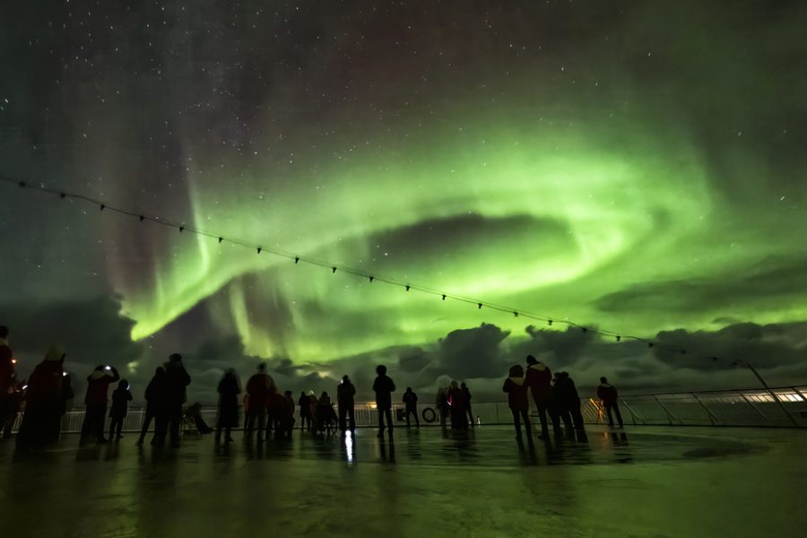 people watching the aurora borealis in Norway on a cruise ship